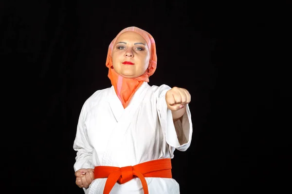 Muslimische Frau im Kimono und Hijab trainiert in einem Karate-Kurs mit ihren Händen. — Stockfoto