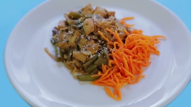 Prato de macarrão de arroz tailandês com legumes de frango e sementes de gergelim em molho Pad Thai. Rotação em um círculo — Vídeo de Stock