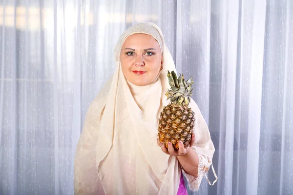 一个穿着浅围巾的年轻穆斯林妇女站在桌子旁,与弗瑞 — 图库照片