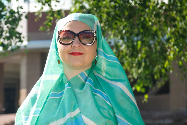 Молодая мусульманка в легком шарфе и в очках на улице . — стоковое фото