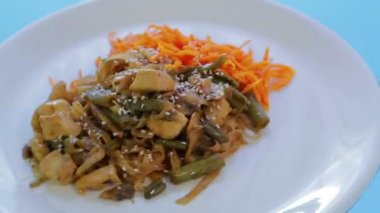 Tavuk sebze ve yastık Tay sosu susam ile Tay Pirinç Noodle çanak. Bir daire içinde döndürme