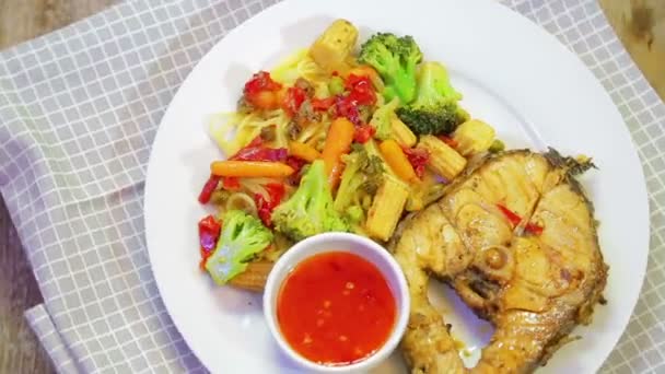Sebze ve Asya sosu ile bir tabak balık ve spagetti bir damalı peçete etrafında döner. — Stok video
