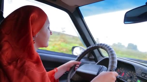 Jovem mulher muçulmana elegante no hijab dirigindo um carro — Vídeo de Stock