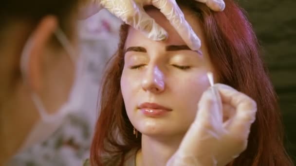 Косметолог застосовує спеціальний гель для клієнтів, пофарбованих в брови — стокове відео