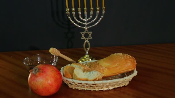 Challah, honing en granaatappel voor de vakantie van Rosh Hashanah naast de menora met kaarsen — Stockvideo