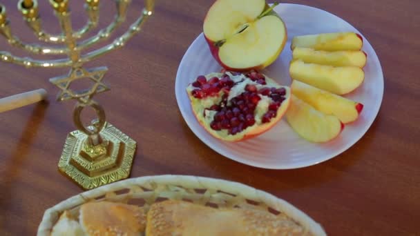 Op de tafel zijn feestelijke traktaties voor Rosh Hashanah Challah, honing en granaatappel — Stockvideo