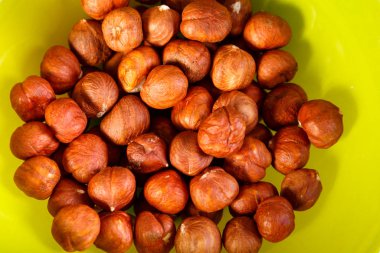 Yeşil bir arka plan üzerine dağılmış koyu fındık.