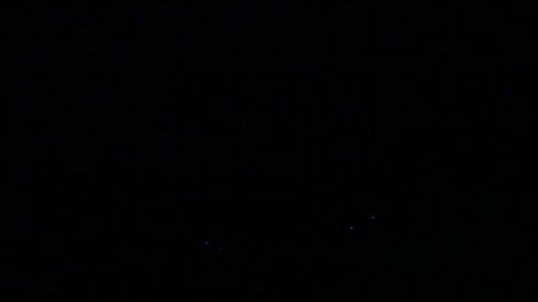 Фигуры праздничных фейерверков в ночном небе над рекой отражены в воде — стоковое видео