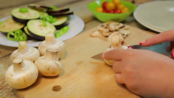 Frau schneidet Champignons mit Messer auf Holzbrett. — Stockvideo