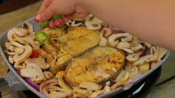 Frauenhand legt Champignon in Scheiben in Fisch — Stockvideo