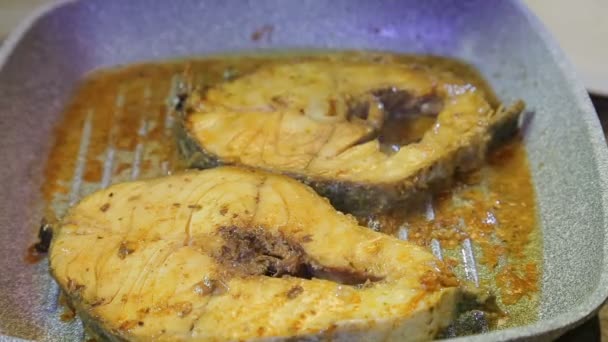 Uma mulher coloca legumes frescos coloridos em uma frigideira com peixe — Vídeo de Stock