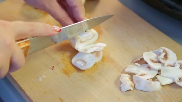 Een vrouw plakjes champignon champignons op platen. — Stockvideo