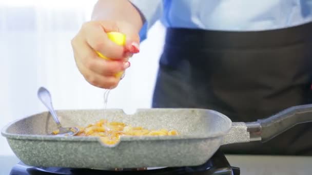 Kobieta wyciskuje sok z cytryny na patelni z makarona ryżu. Czas okrążeń — Wideo stockowe