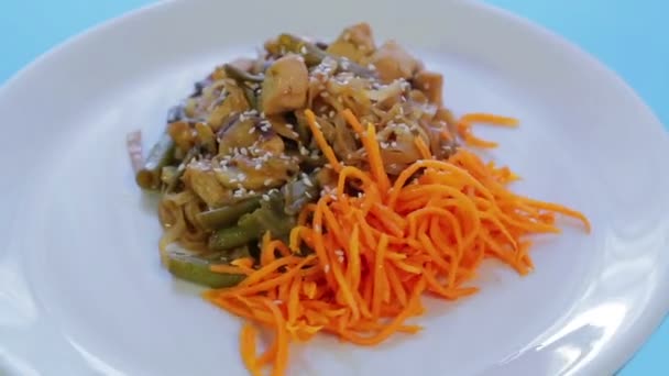 Plato de fideos de arroz tailandés con verduras de pollo y semillas de sésamo en salsa Pad Thai. Rotación en círculo . — Vídeo de stock