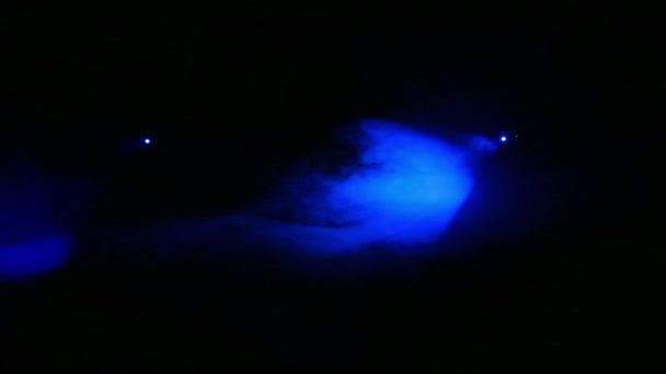 La luce viene generata riflettori profilo blu al buio in una coperta di fumo . — Video Stock