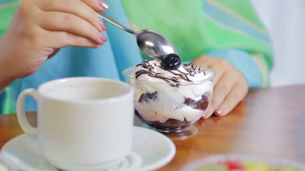 Uma mulher em um café come bolos e bebe chá . — Vídeo de Stock