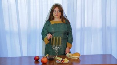 Bir Yahudi kadın davranır ile şenlikli partide Rosh Hashanah üzerinde güzel bir mum çubuğunda mumlar yanar
