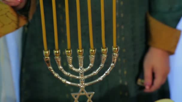 Uma mulher judia acende velas em Rosh Hashaná em uma festa festiva com guloseimas — Vídeo de Stock