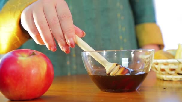 Жіноча рука бере палицю з медом і перевіряє щільність на свято Рош Ашан — стокове відео