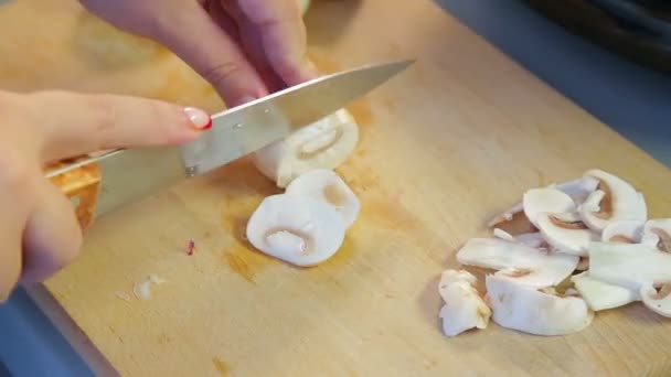 Uma mulher corta cogumelos champignon em pratos — Vídeo de Stock