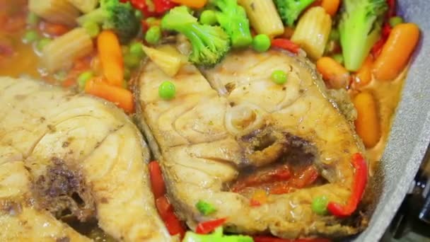 Stek grönsaker och fisk i kokande olja — Stockvideo