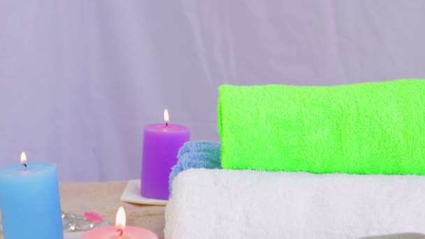 Salón de spa con velas, toallas y piedras para la terapia — Vídeo de stock