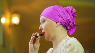 Bir ayna önünde evli bir Jewess kırmızı bir ponpon dudakları boyar