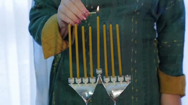 Mujer judía enciende velas en Hanukkah en un hermoso candelero — Vídeos de Stock