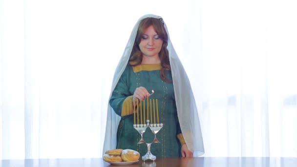 Żydowska kobieta świeci świece na Chanuka w pięknym Świecznik — Wideo stockowe