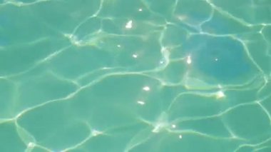 Havuzun mavi su yüzeyinde güneş parlama.