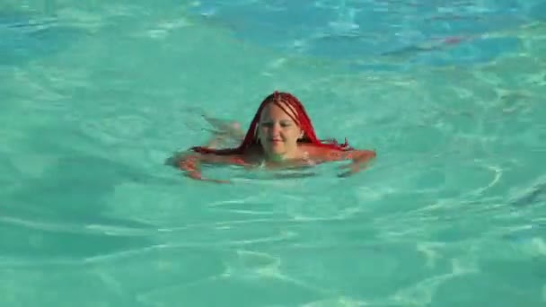 A woman with African pigtails swims in the pool. — Stock Video