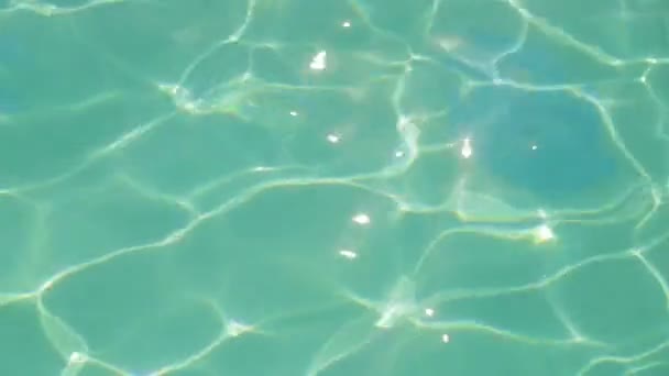 Zon schittering op het oppervlak van het blauwe water van het zwembad. — Stockvideo