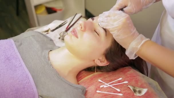 A kozmetikus eltávolítja a felesleges Henna az ügyfelek várárok és alkalmazza krém szemöldöke. — Stock videók