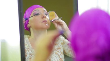 Evli bir Jewess aynaya yansıyan göz farı ile makyaj yapar