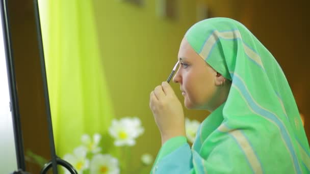 Мусульманка перед зеркалом с кистью — стоковое видео