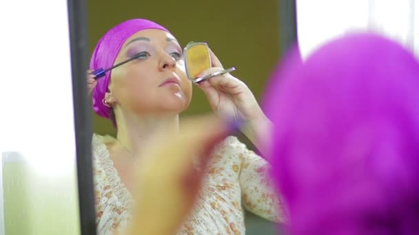 Женатая еврейка делает макияж с тенью для глаз, отраженной в зеркале — стоковое видео