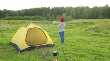 Bir adam ve bir kadın çadırın yanında hayranlıkla doğaya sarılan.