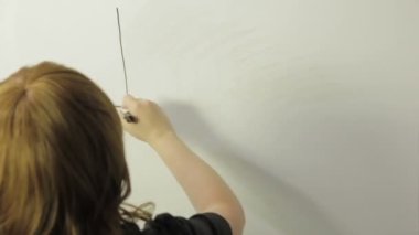Kadın beyaz bir tahta üzerinde bitcoin para grafiği çizer.