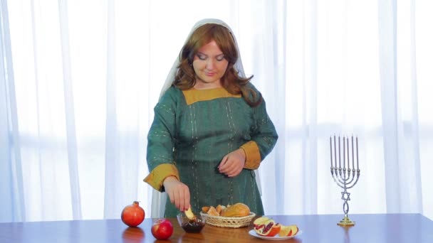 Una donna ebrea prende una fetta di mela e la immerge nel miele per Rosh Hashanah. — Video Stock