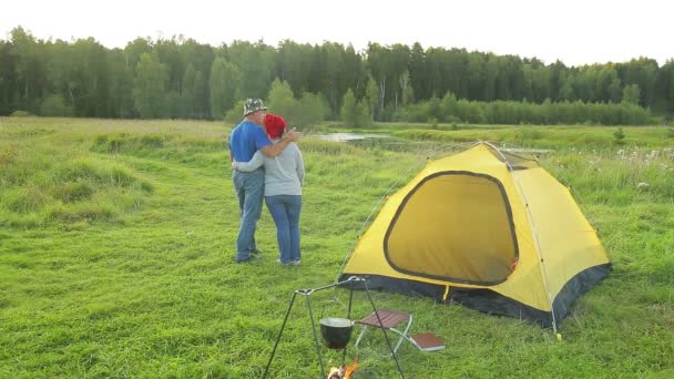 En man och en kvinna nära tältet kramar beundra naturen — Stockvideo