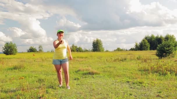 Женщина на поляне подает и бьет по мячу во время игры в бадминтон — стоковое видео