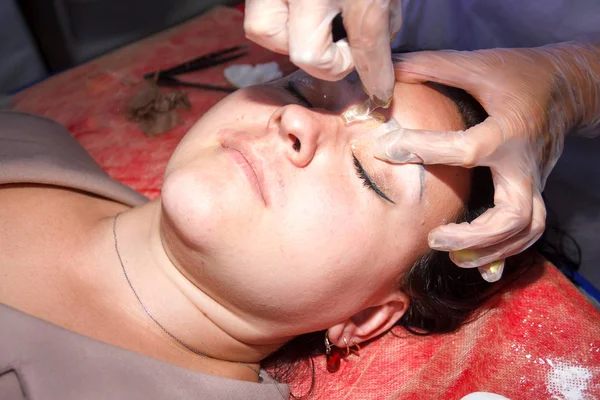 El cosmetólogo corrige las cejas del cliente por el método de shugaring. primer plano . — Foto de Stock