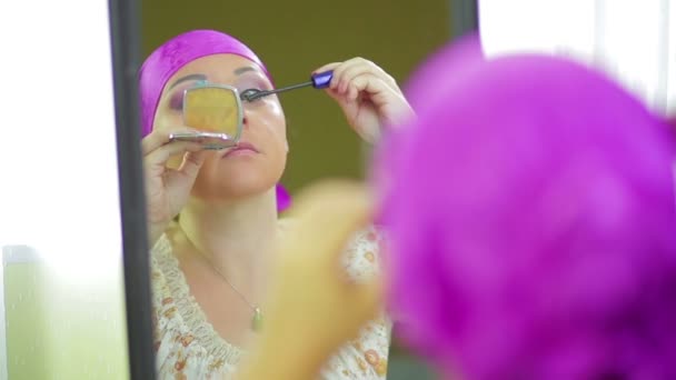 Una judía casada maquilla con sombra de ojos reflejada en el espejo — Vídeo de stock