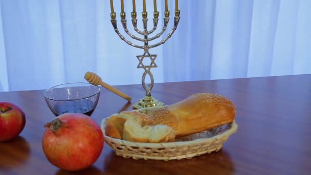 Challah, miel y granada para la fiesta de Rosh Hashaná junto a la menorá con velas — Vídeo de stock