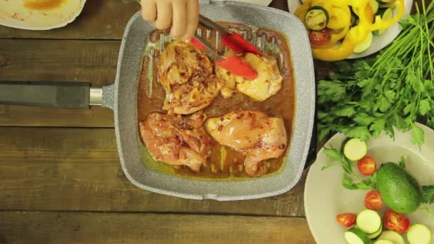 Mano femminile mescolando con pinze di pollo in una padella griglia. Giri temporali . — Video Stock