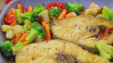 Bir sos ızgara bir tavada sebze ile ızgara balık.