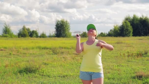 Žena na mýtině slouží a zasáhne míč, když hraje badminton. — Stock video