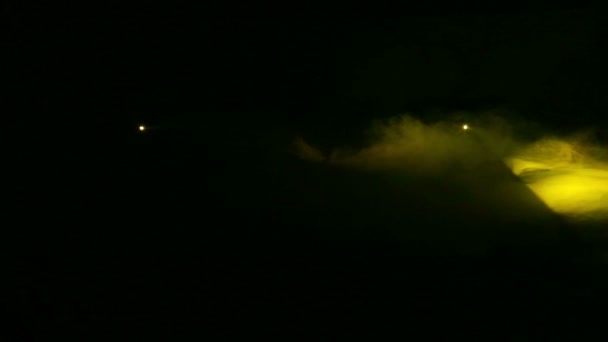 La luce viene generata riflettori profilo giallo al buio in una coperta di fumo — Video Stock