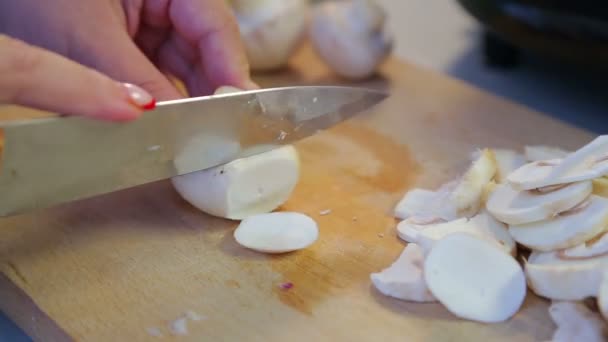 Uma mulher corta cogumelos champignon em pratos — Vídeo de Stock