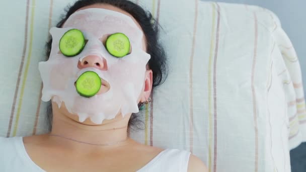 A male beautician makes a female client a vegetable therapy on her face in a spa salon — Stock Video